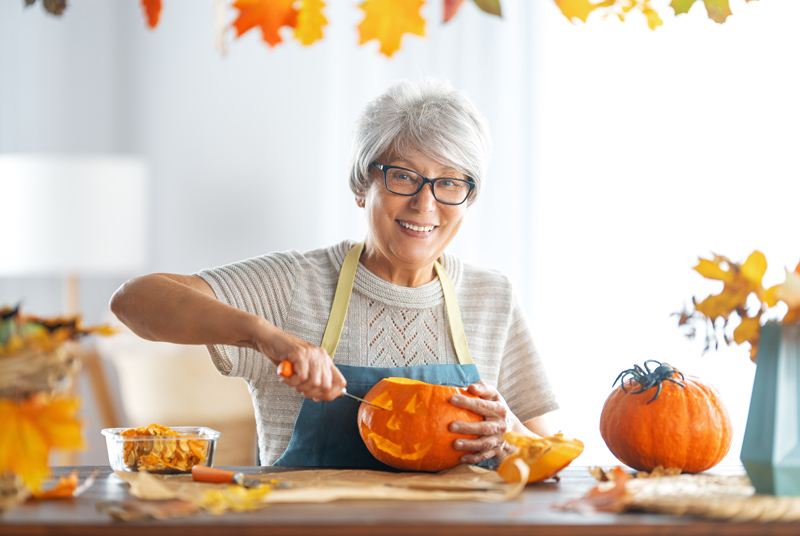 Senior carving Halloween pumpkin at retirement community in Squamish