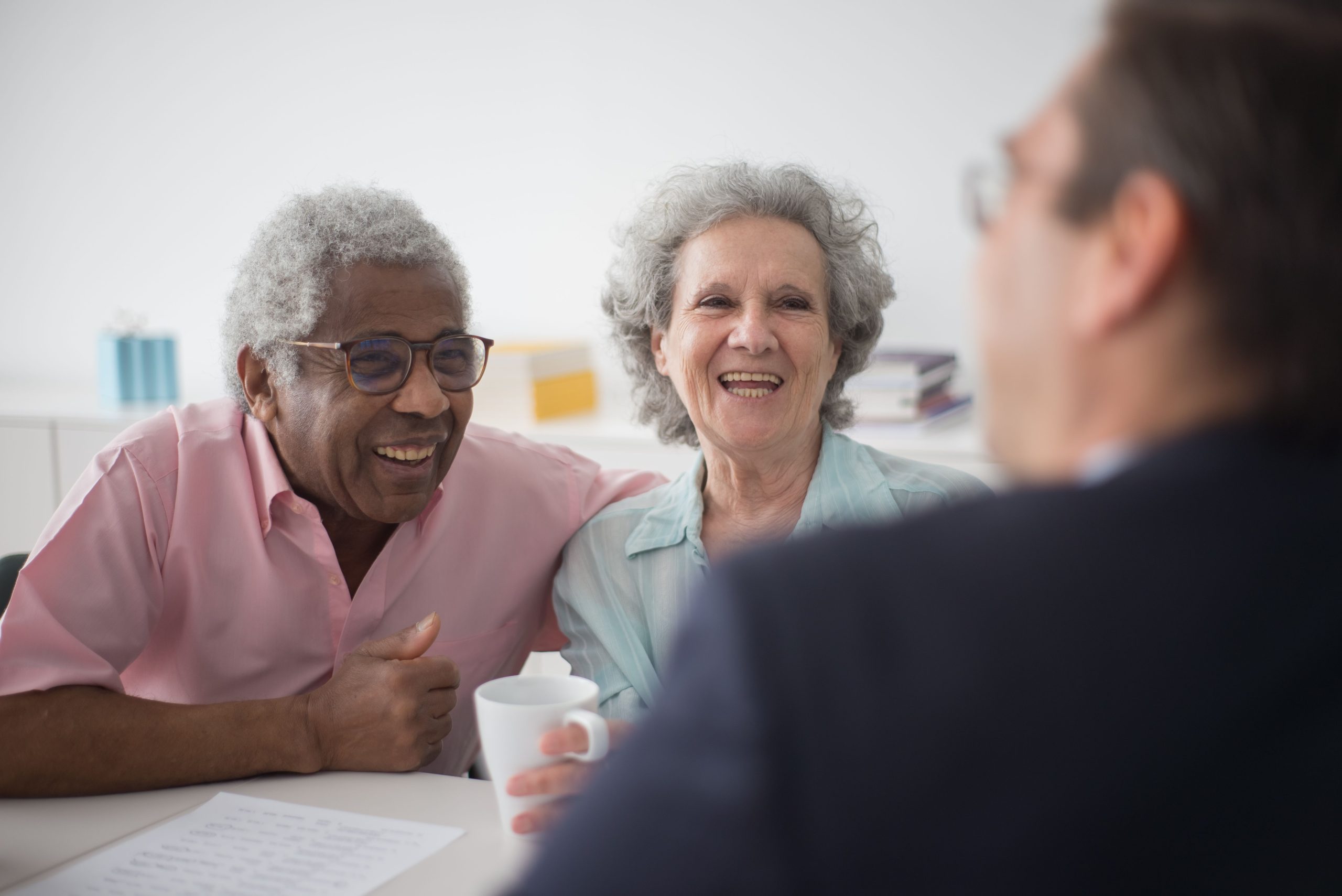 two seniors over coffee laughing